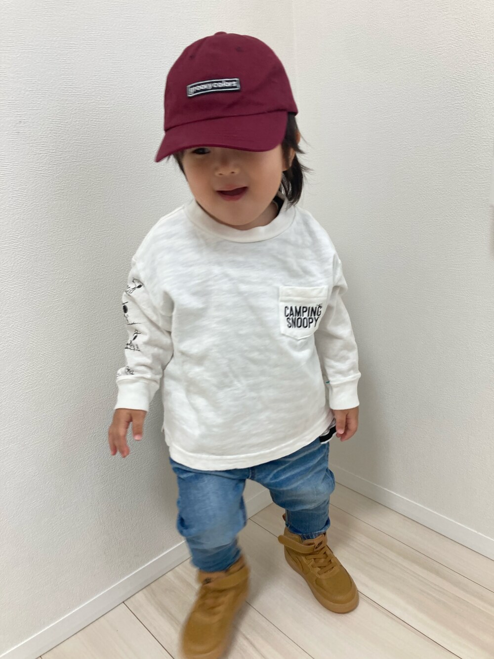 ホワイト系のTシャツ/カットソー、ブルー系のデニムパンツ、ブラウン系のスニーカーを着用したキッズの冬コーディネートの2枚目の写真