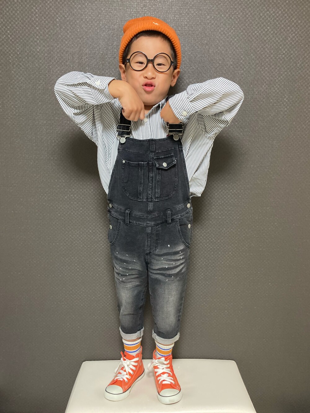 ブラック系のシャツ/ブラウス、オレンジ系のスニーカー、オレンジ系のニットキャップ/ビーニーを着用したキッズの秋コーディネートの3枚目の写真