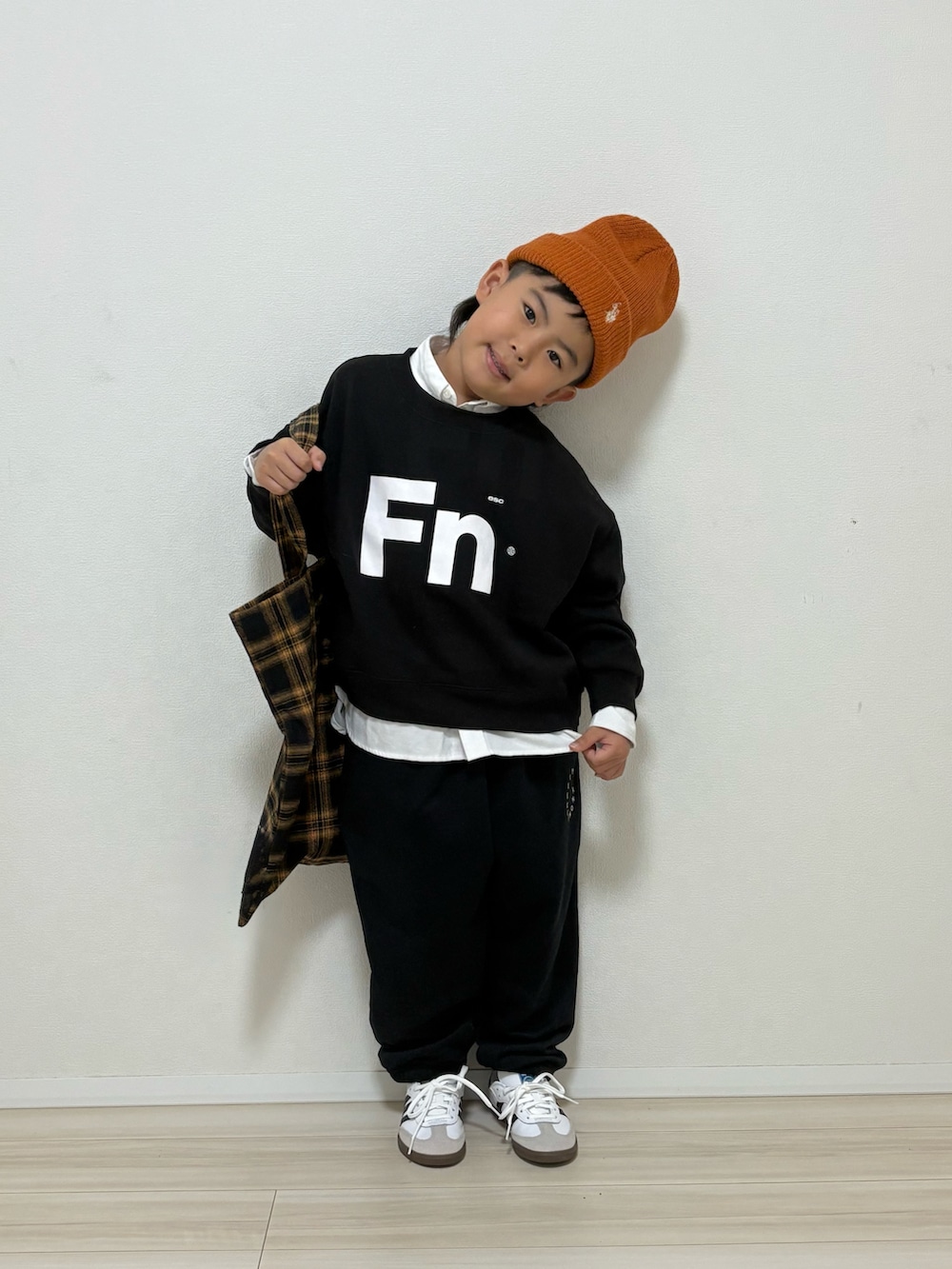 ブラック系のスウェット、ブラック系のスウェットパンツ、ホワイト系のスニーカーを着用したキッズの冬コーディネートの2枚目の写真