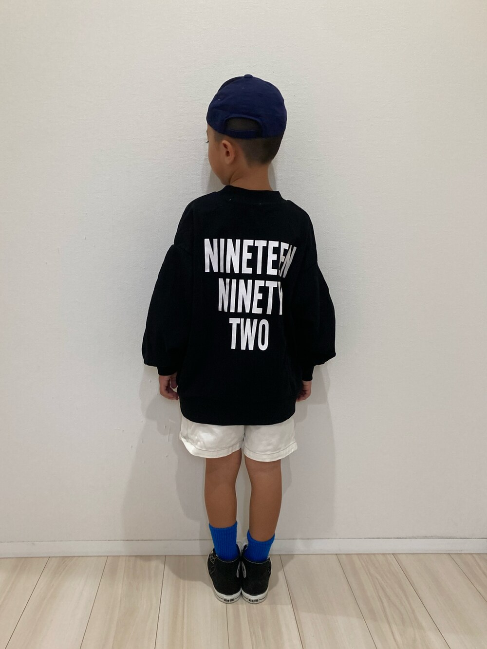 ブラック系のスウェット、ホワイト系のその他パンツ、ブラック系のスニーカーを着用したキッズの秋コーディネートの4枚目の写真