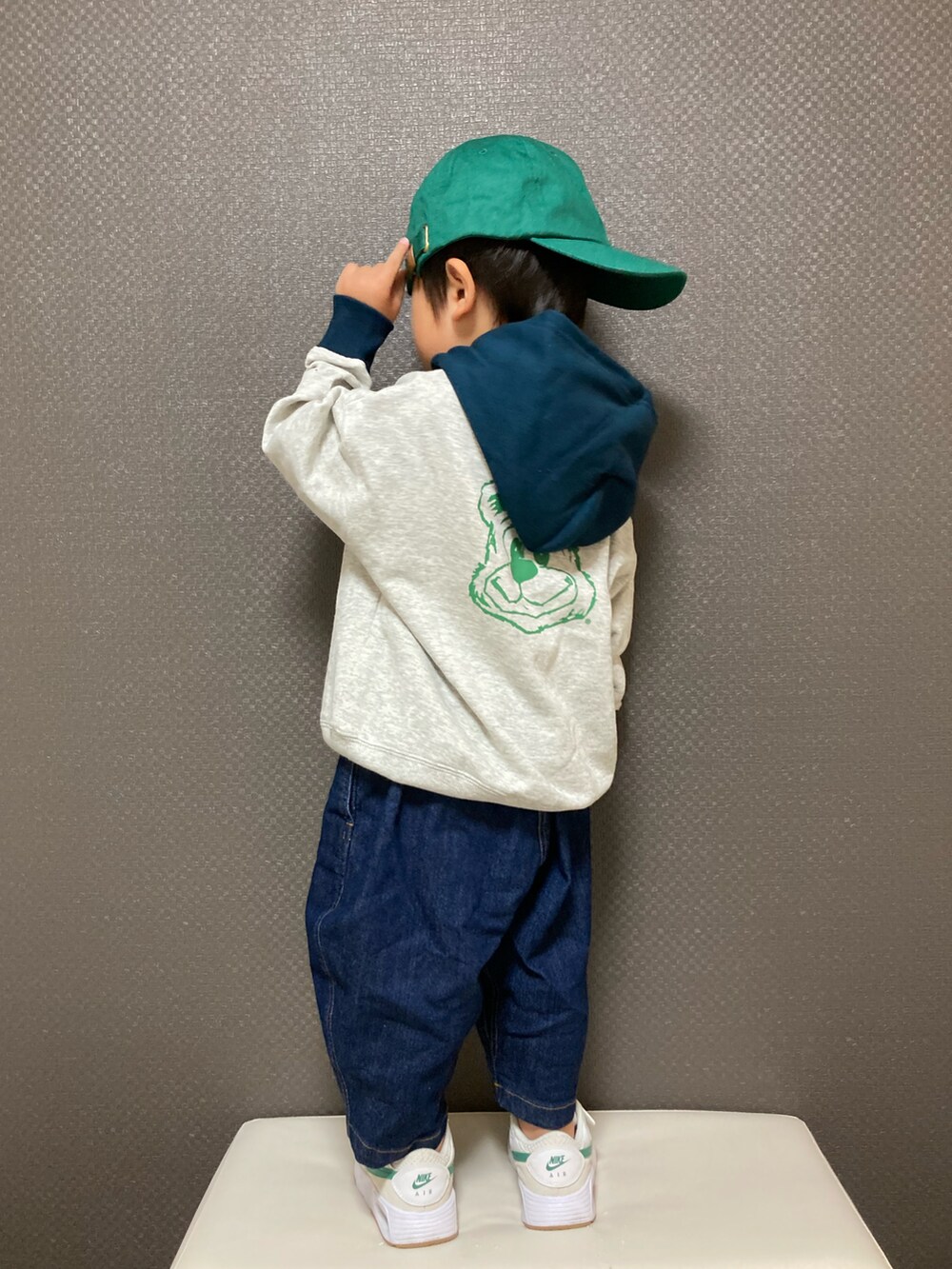 ホワイト系のパーカー、ブルー系のデニムパンツ、ホワイト系のスニーカーを着用したキッズの秋コーディネートの2枚目の写真
