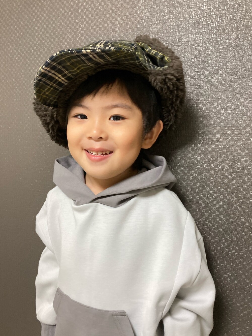 グレー系のスウェット、ブルー系のチノパンツ、ブラック系のスニーカーを着用したキッズの秋コーディネートの4枚目の写真