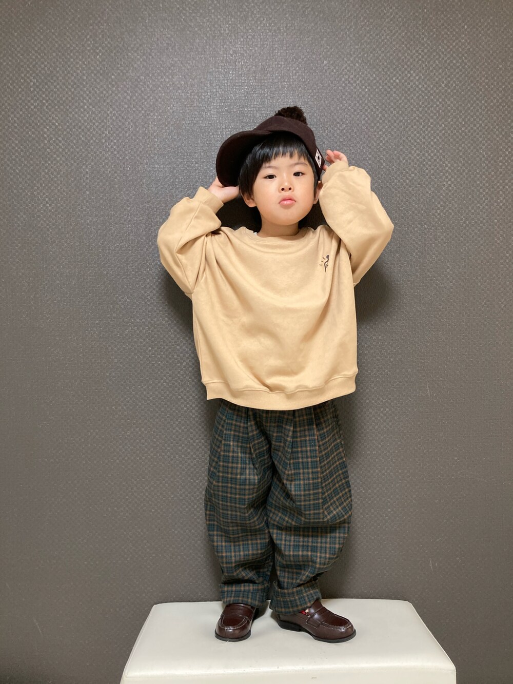 ブラウン系のスウェット、グリーン系のその他パンツ、ブラウン系のローファーを着用したキッズの秋コーディネートの2枚目の写真