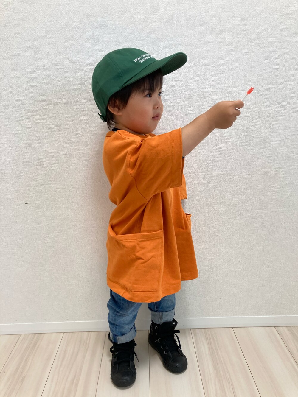 オレンジ系のTシャツ/カットソー、ブルー系のデニムパンツ、ブラック系のスニーカーを着用したキッズの春コーディネートの4枚目の写真