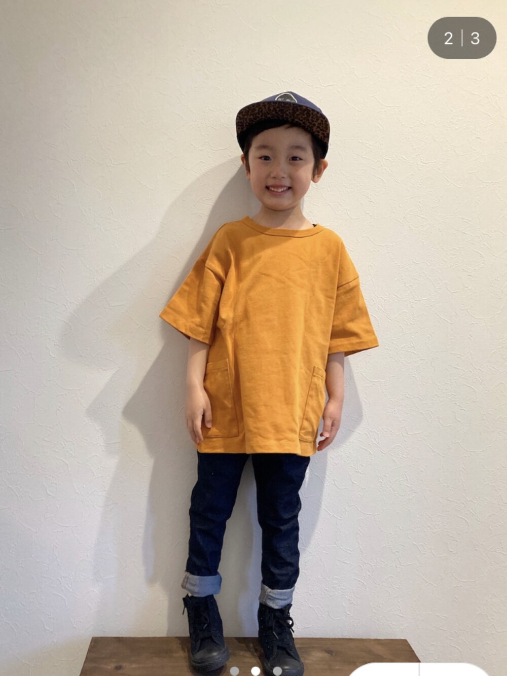 オレンジ系のTシャツ/カットソー、ブルー系のデニムパンツ、ブラック系のスニーカーを着用したキッズの春コーディネートの2枚目の写真