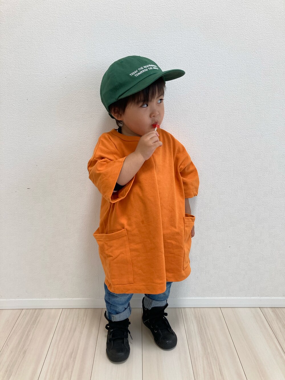 オレンジ系のTシャツ/カットソー、ブルー系のデニムパンツ、ブラック系のスニーカーを着用したキッズの春コーディネートの3枚目の写真