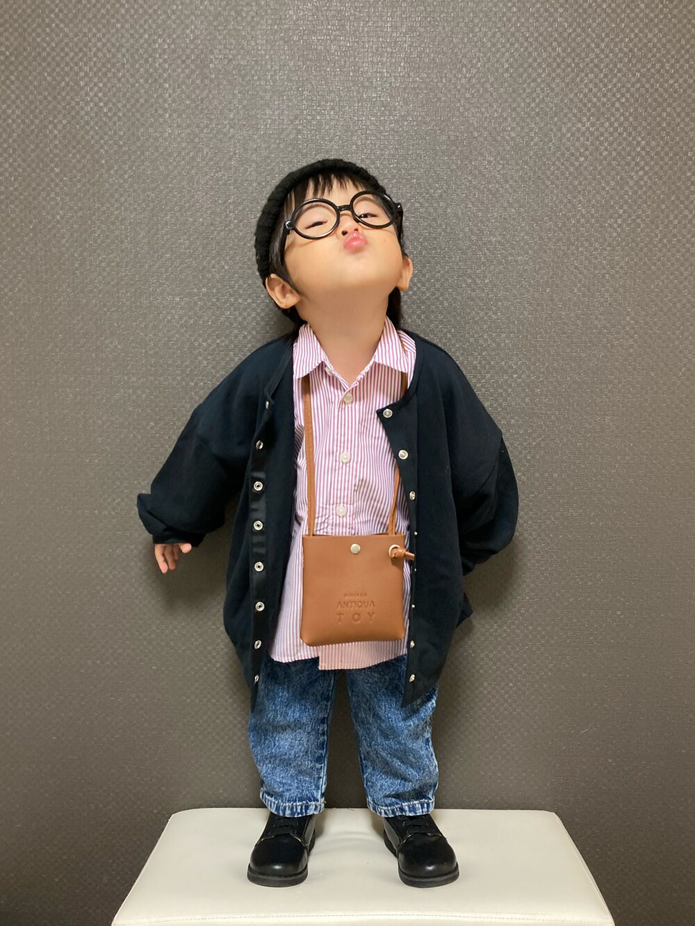 ブラウン系のショルダーバッグ、ピンク系のシャツ/ブラウス、ブルー系のデニムパンツを着用したキッズの秋コーディネートの4枚目の写真