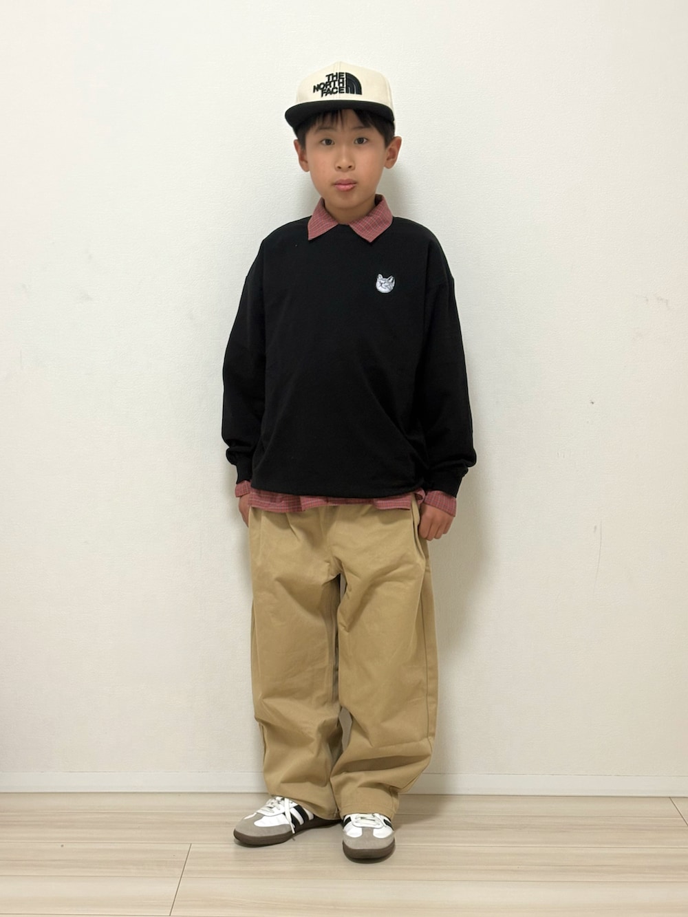 ブラック系のTシャツ/カットソー、ベージュ系のその他パンツ、ホワイト系のスニーカーを着用したキッズの冬コーディネートの2枚目の写真