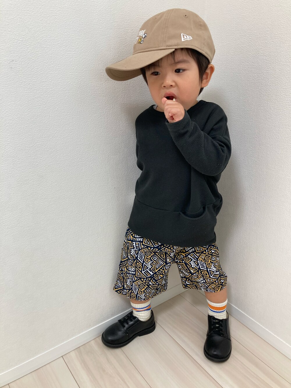 ブラック系のTシャツ/カットソー、オレンジ系のその他パンツ、ブラック系のドレスシューズを着用したキッズの春コーディネートの2枚目の写真