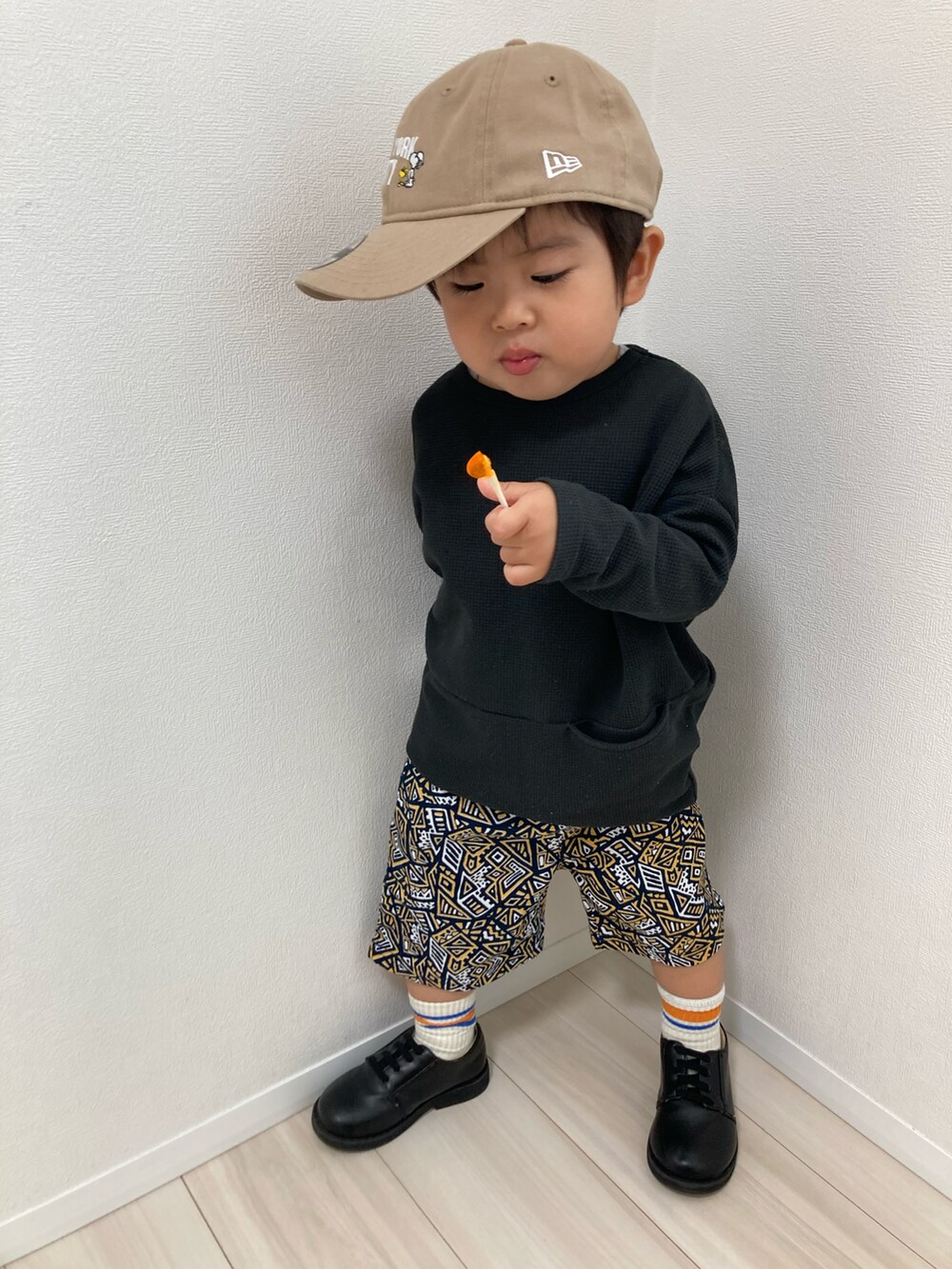 ブラック系のTシャツ/カットソー、オレンジ系のその他パンツ、ブラック系のドレスシューズを着用したキッズの春コーディネートの3枚目の写真