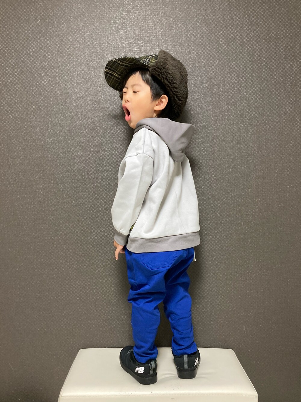 グレー系のスウェット、ブルー系のチノパンツ、ブラック系のスニーカーを着用したキッズの秋コーディネートの2枚目の写真