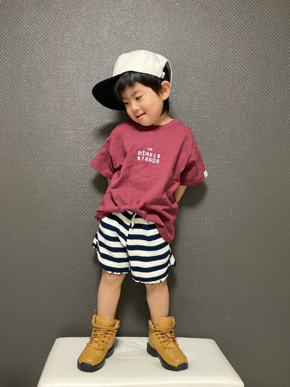 レッド系のTシャツ/カットソー、ブラック系のパンツ、ブラウン系のブーツを着用したキッズの夏コーディネートの2枚目の写真