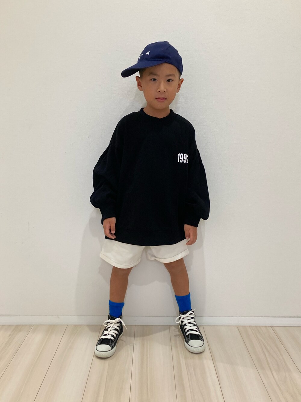 ブラック系のスウェット、ホワイト系のその他パンツ、ブラック系のスニーカーを着用したキッズの秋コーディネートの2枚目の写真