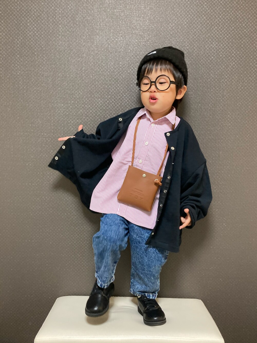 ブラウン系のショルダーバッグ、ピンク系のシャツ/ブラウス、ブルー系のデニムパンツを着用したキッズの秋コーディネートの2枚目の写真