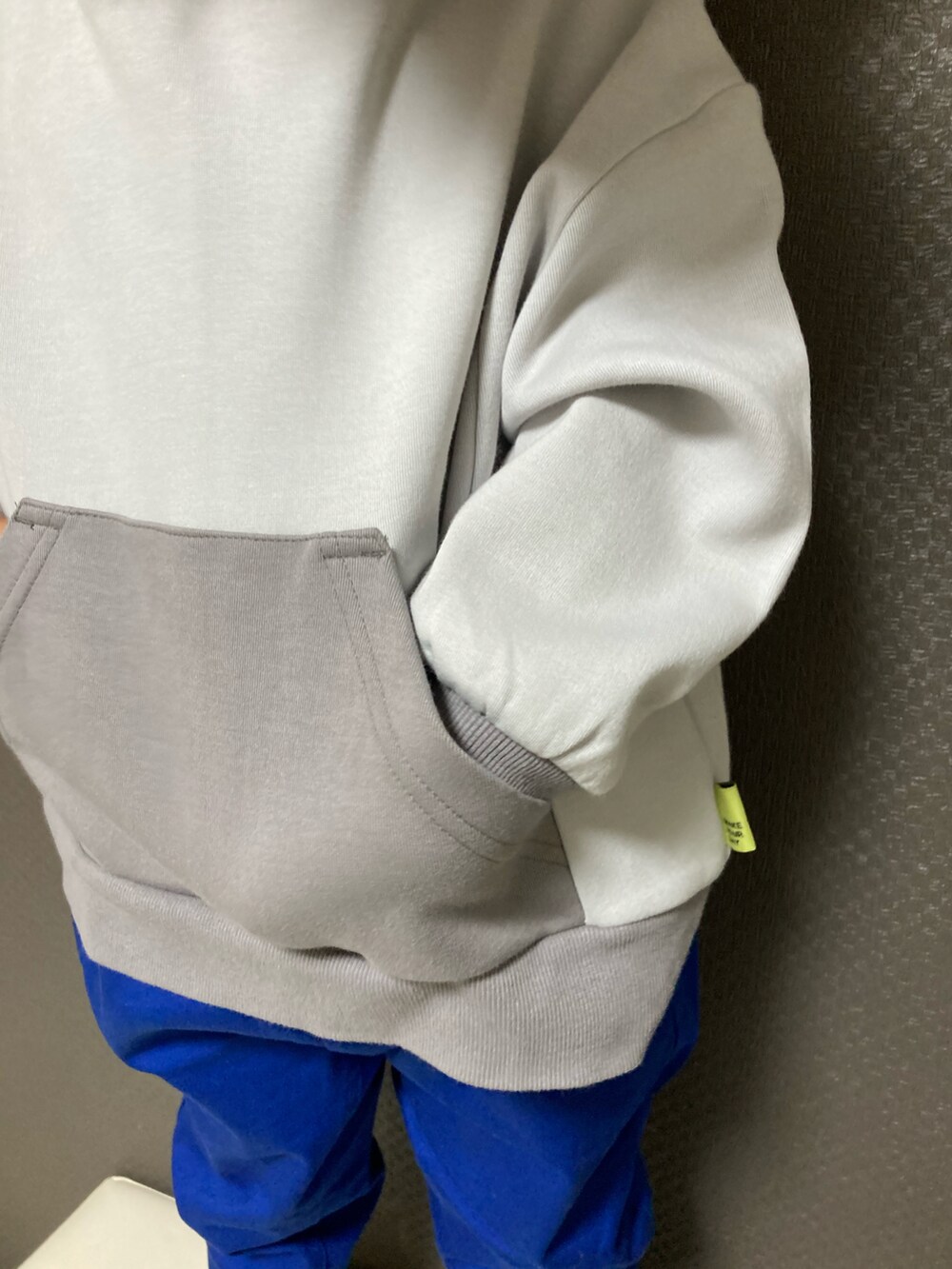 グレー系のスウェット、ブルー系のチノパンツ、ブラック系のスニーカーを着用したキッズの秋コーディネートの3枚目の写真