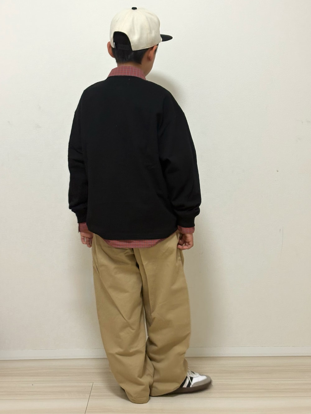 ブラック系のTシャツ/カットソー、ベージュ系のその他パンツ、ホワイト系のスニーカーを着用したキッズの冬コーディネートの4枚目の写真