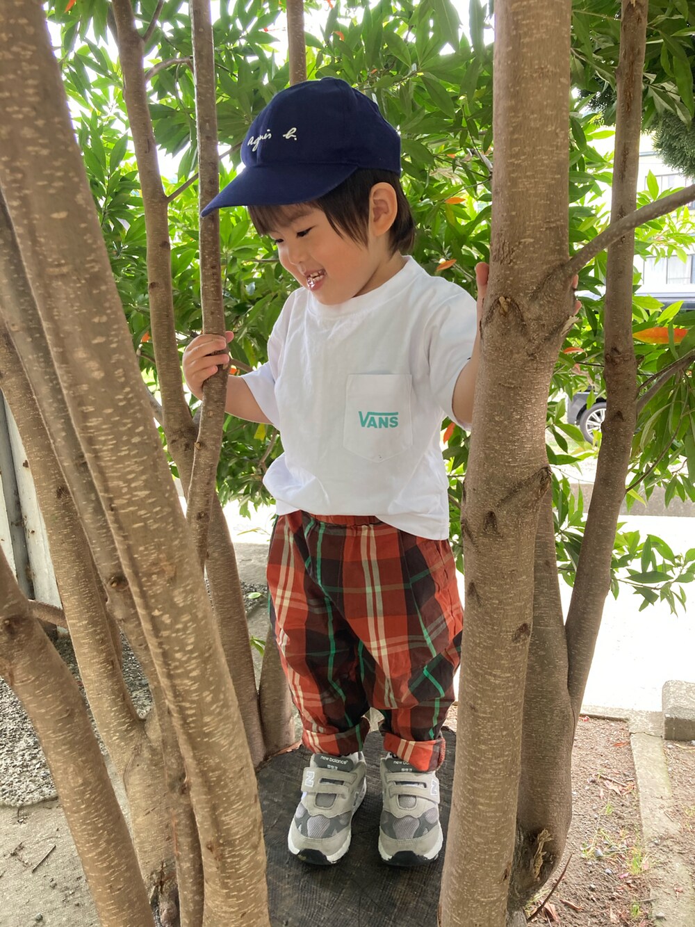 ブラウン系のパンツ、グレー系のスニーカー、ホワイト系のTシャツ/カットソーを着用したキッズの夏コーディネートの3枚目の写真