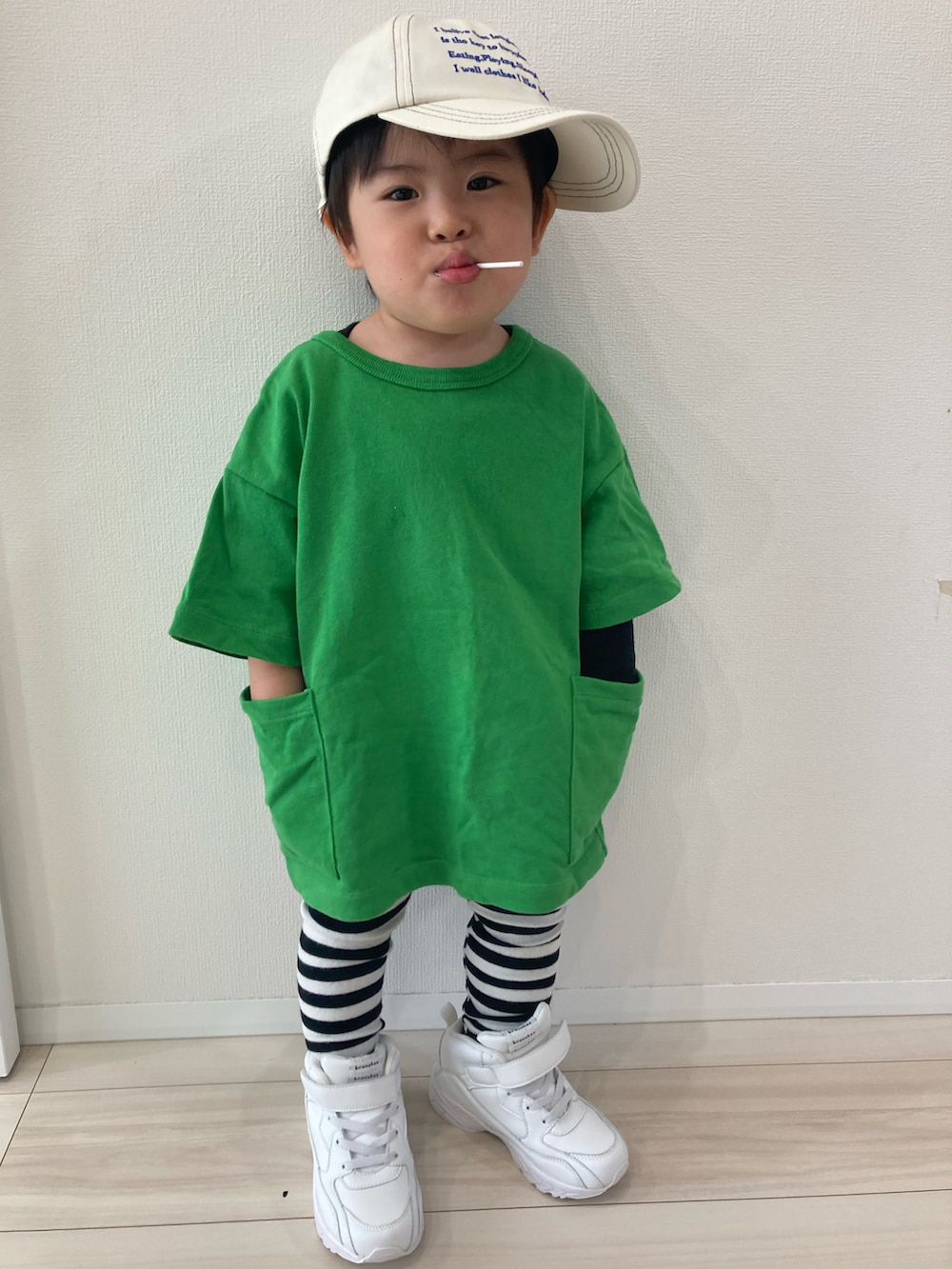 グリーン系のTシャツ/カットソー、ホワイト系のスニーカー、ホワイト系のキャップを着用したキッズの春コーディネートの2枚目の写真