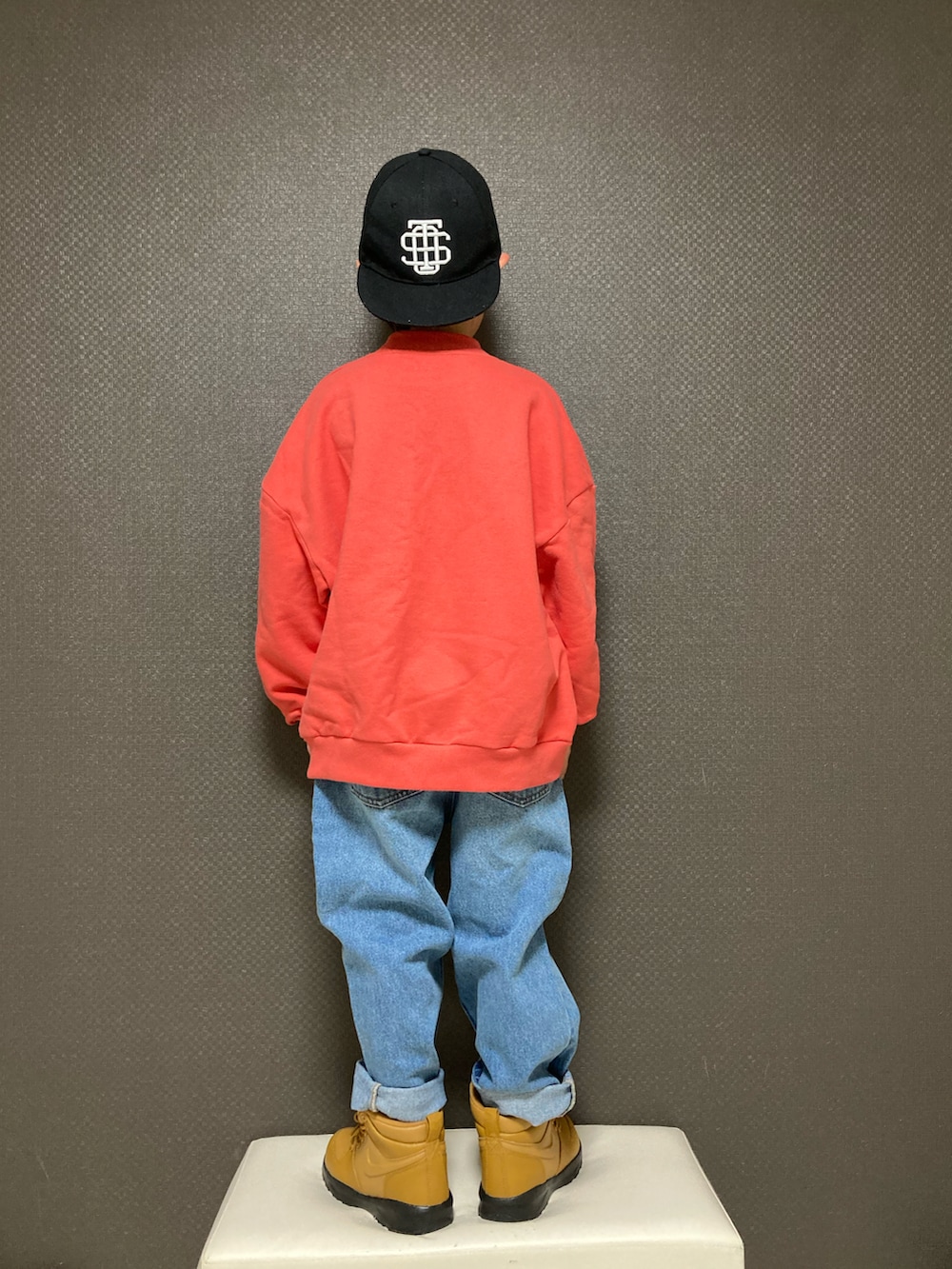 レッド系のスウェット、ブルー系のデニムパンツ、ブラウン系のスニーカーを着用したキッズの春コーディネートの2枚目の写真