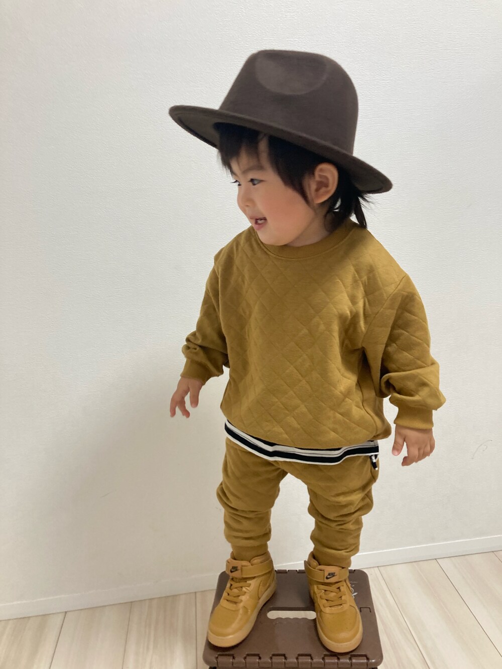 イエロー系のスウェット、イエロー系のその他パンツ、ブラウン系のスニーカーを着用したキッズの冬コーディネートの2枚目の写真