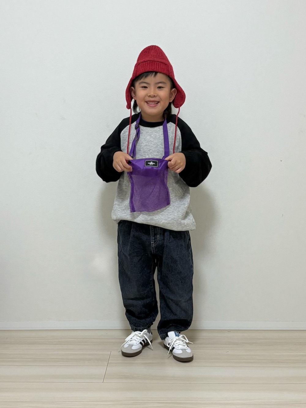 グレー系のスウェット、ブルー系のデニムパンツ、ホワイト系のスニーカーを着用したキッズの冬コーディネートの2枚目の写真