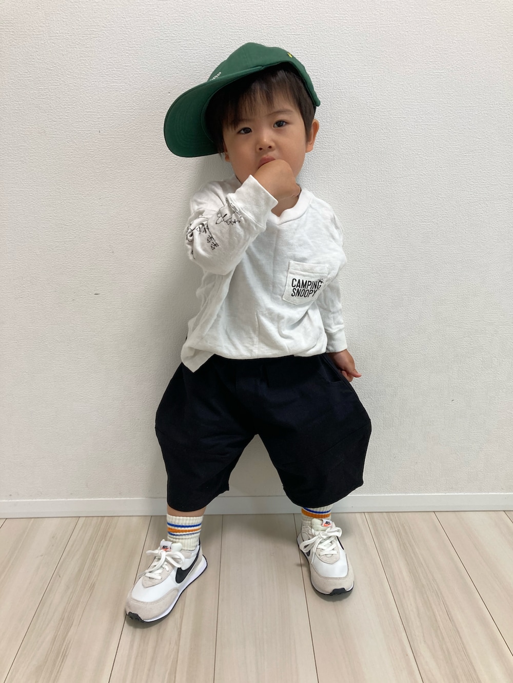 ホワイト系のTシャツ/カットソー、ブラック系のチノパンツ、ホワイト系のその他シューズを着用したキッズの春コーディネートの3枚目の写真