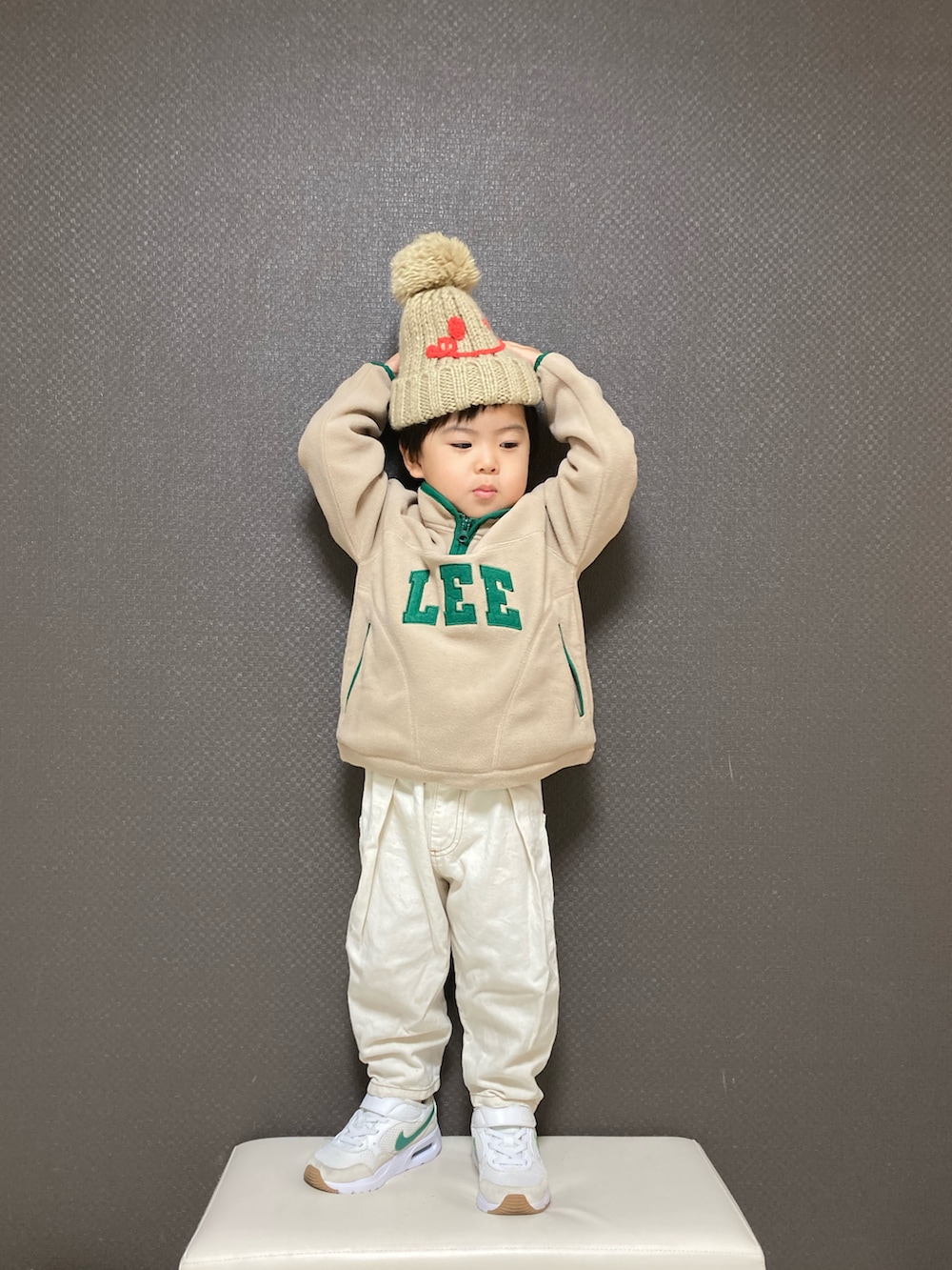 ベージュ系のその他トップス、ホワイト系のデニムパンツ、ホワイト系のスニーカーを着用したキッズの冬コーディネートの3枚目の写真