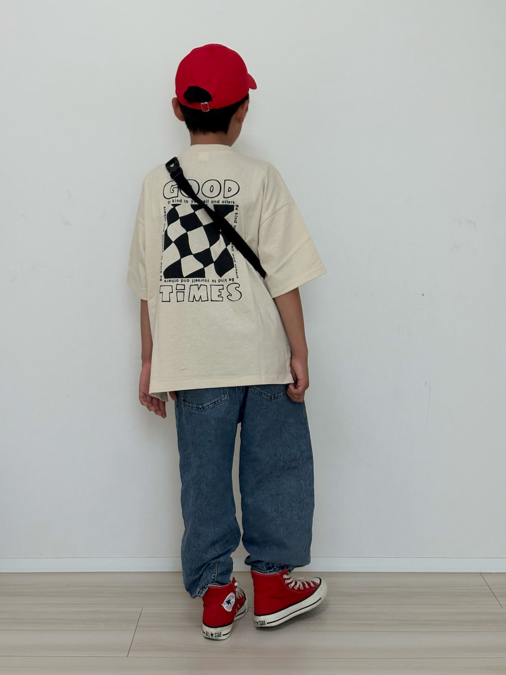 ホワイト系のTシャツ/カットソー、ブルー系のデニムパンツ、レッド系のスニーカーを着用したキッズの春コーディネートの4枚目の写真