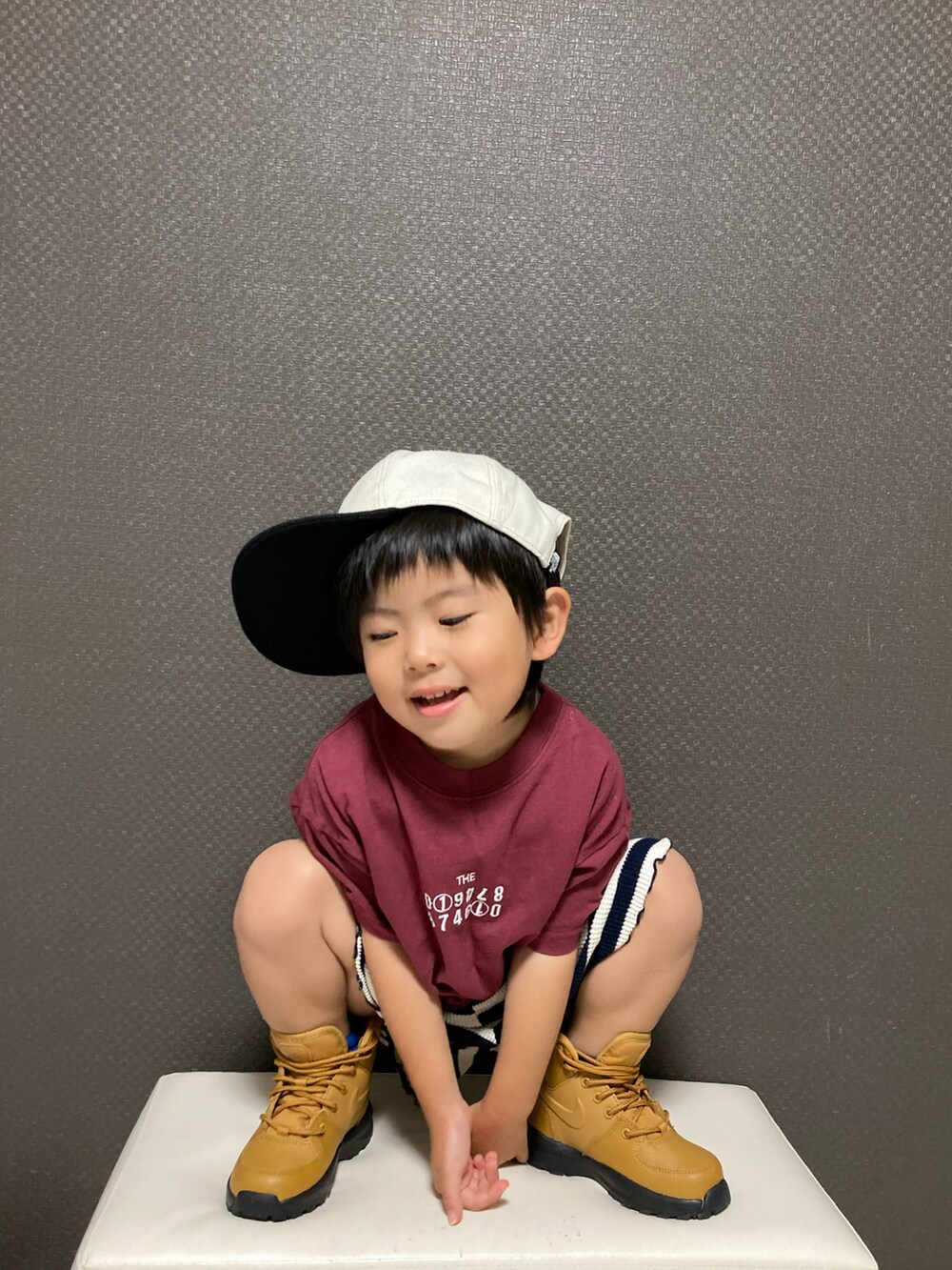 レッド系のTシャツ/カットソー、ブラック系のパンツ、ブラウン系のブーツを着用したキッズの夏コーディネートの3枚目の写真