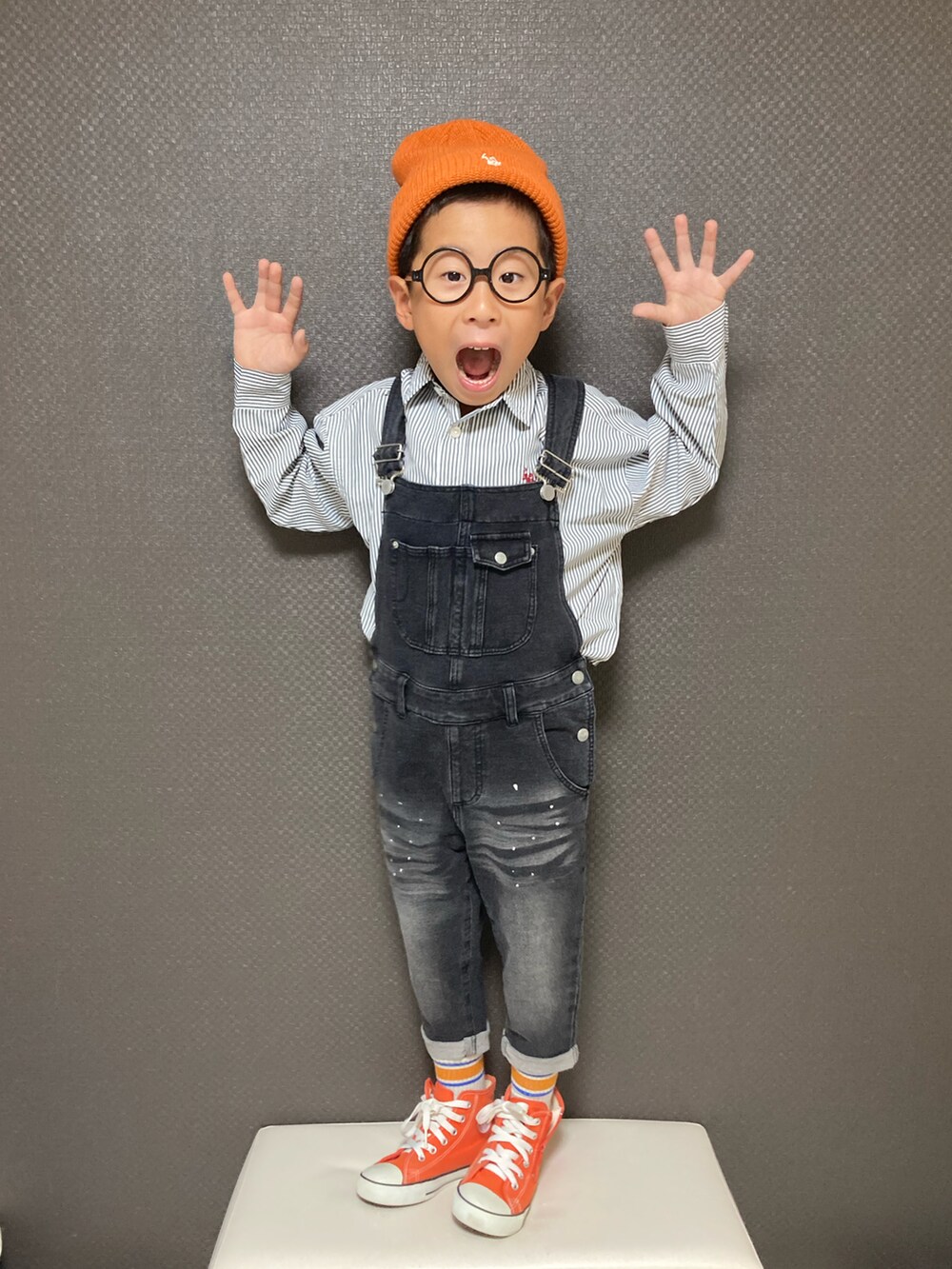 ブラック系のシャツ/ブラウス、オレンジ系のスニーカー、オレンジ系のニットキャップ/ビーニーを着用したキッズの秋コーディネートの2枚目の写真