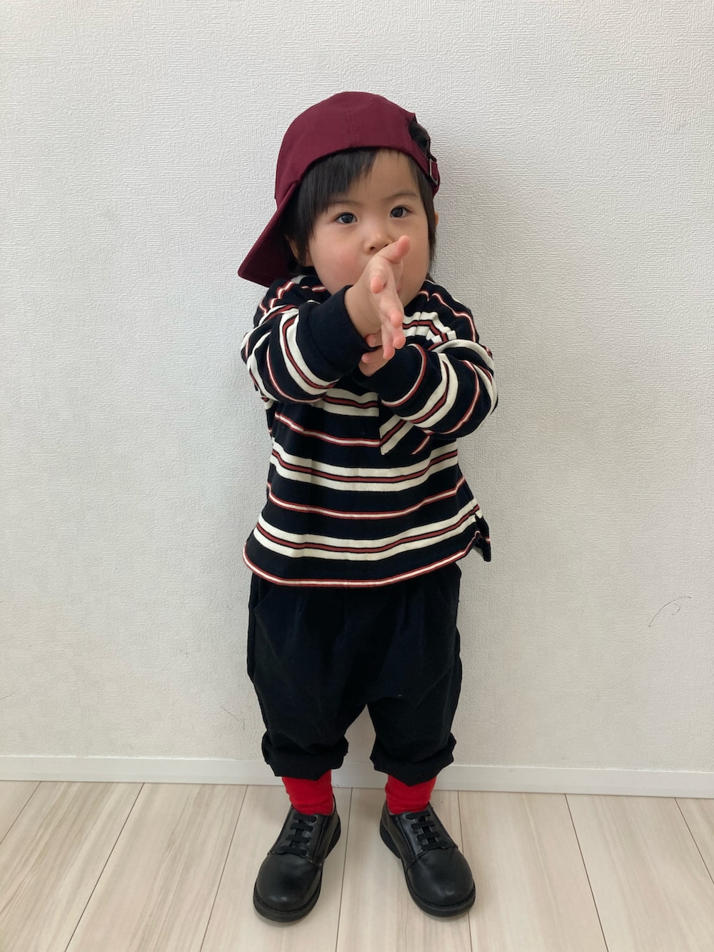 ブラック系のスウェット、ブラック系のスラックス、ブラック系のドレスシューズを着用したキッズの春コーディネートの2枚目の写真