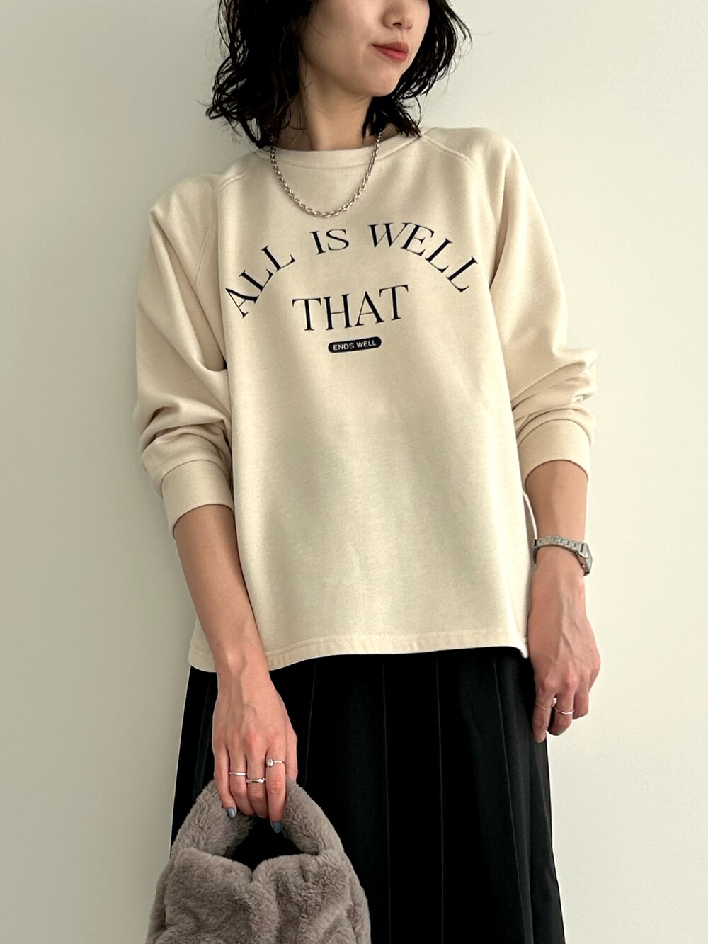 ホワイト系のTシャツ/カットソー、グレー系のハンドバッグ、ブラック系のスカートを着用したレディースの冬コーディネートの2枚目の写真