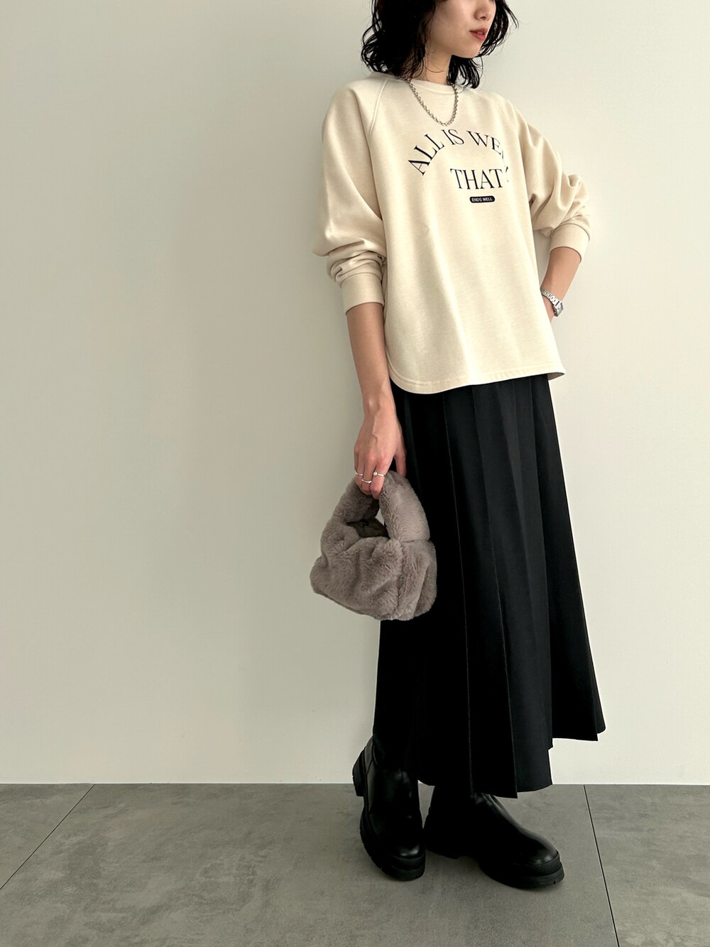 ホワイト系のTシャツ/カットソー、グレー系のハンドバッグ、ブラック系のスカートを着用したレディースの冬コーディネートの4枚目の写真