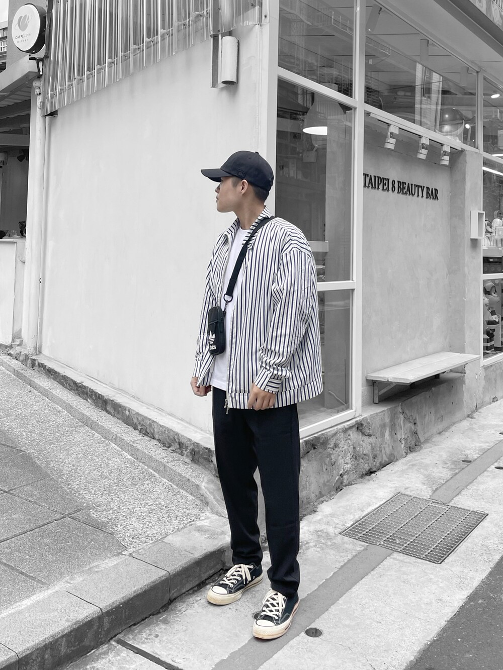 ブラック系のスニーカー、ブラック系のキャップを着用したメンズの春コーディネートの2枚目の写真