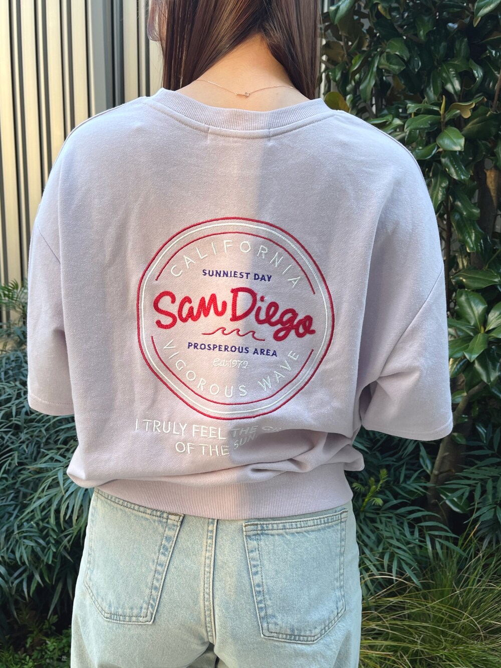 ピンク系のTシャツ/カットソー、ブルー系のデニムパンツ、オレンジ系のバレッタ/ヘアクリップを着用したレディースの春コーディネートの4枚目の写真