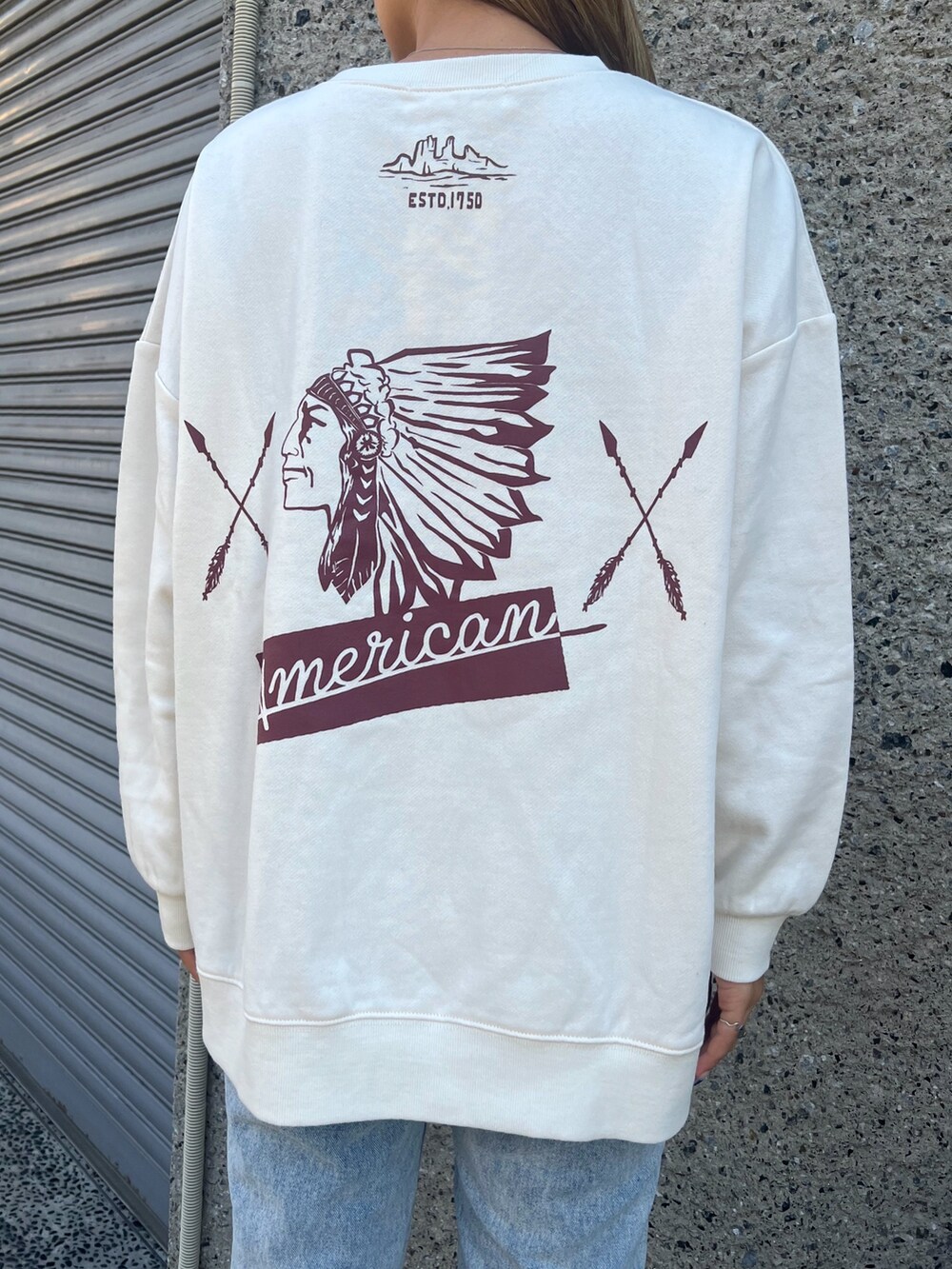 ブルー系のデニムパンツ、グリーン系のダウンジャケット/コート、ベージュ系のスウェットを着用したレディースの冬コーディネートの6枚目の写真