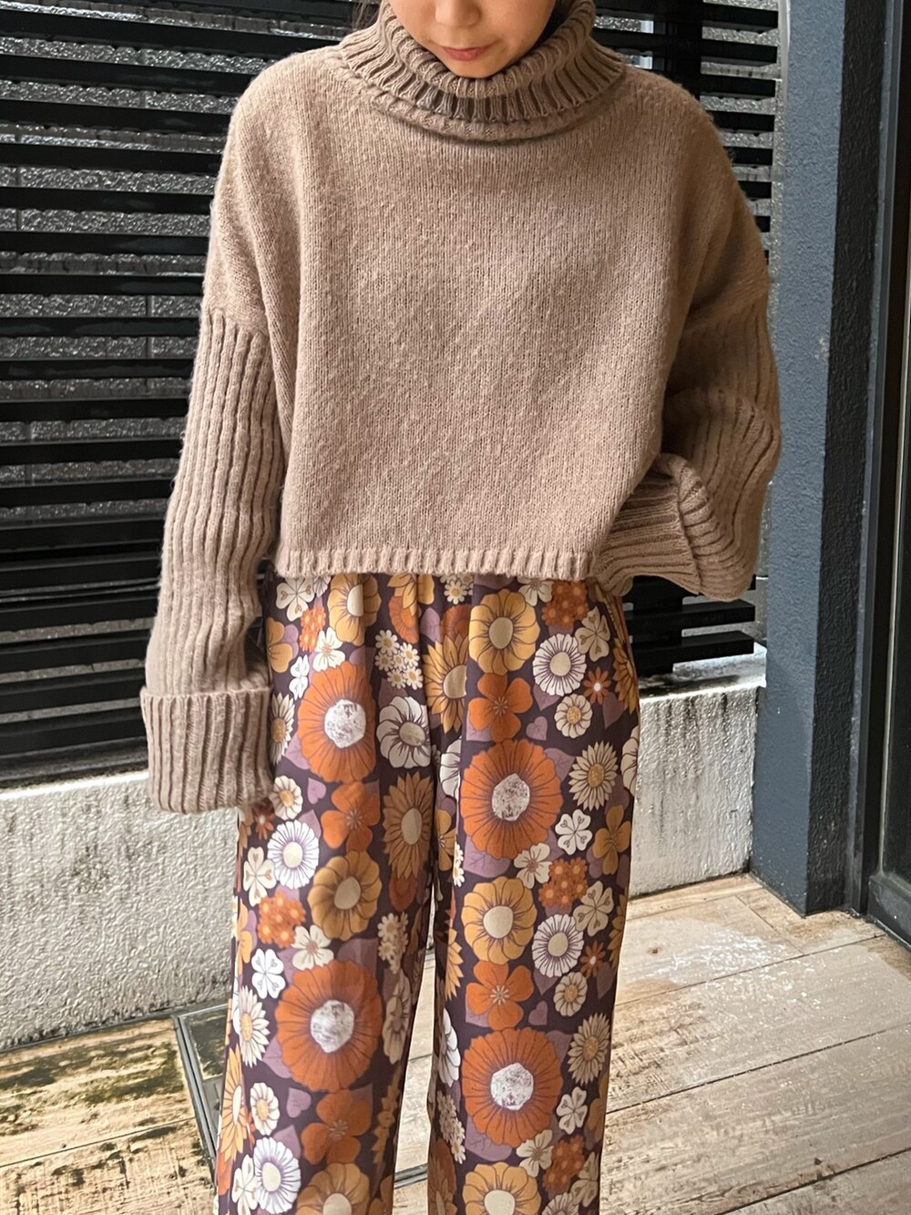 ブラウン系のニット/セーター、ベージュ系のショルダーバッグ、ベージュ系のスニーカーを着用したレディースの冬コーディネートの2枚目の写真