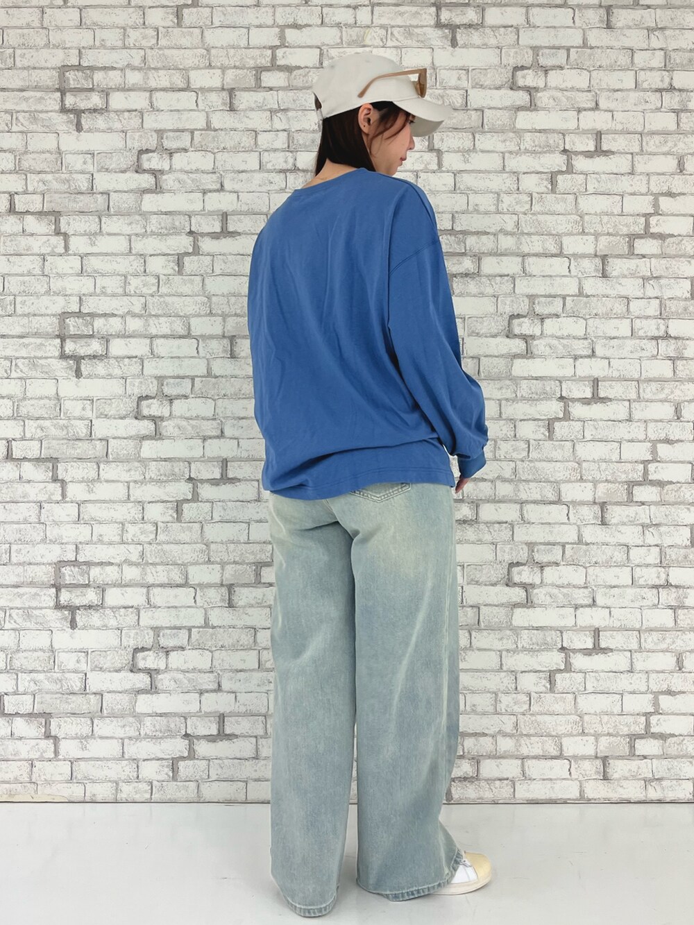 ブルー系のTシャツ/カットソー、ブルー系のデニムパンツ、ホワイト系のキャップを着用したレディースの春コーディネートの2枚目の写真