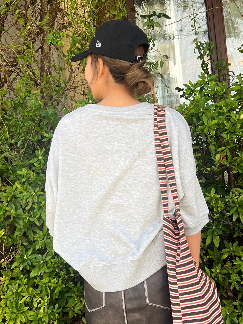 グレー系のTシャツ/カットソー、ブラウン系のスカート、グレー系のスニーカーを着用したレディースの春コーディネートの3枚目の写真
