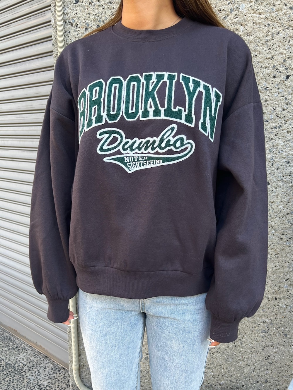 ブルー系のデニムパンツ、グレー系のスウェット、ブラック系のショルダーバッグを着用したレディースの冬コーディネートの3枚目の写真