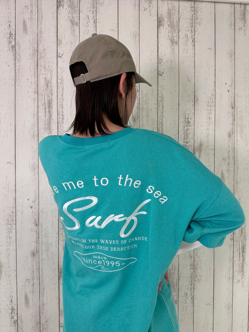 ブルー系のTシャツ/カットソー、ホワイト系のスニーカー、ベージュ系のキャップを着用したレディースの春コーディネートの2枚目の写真
