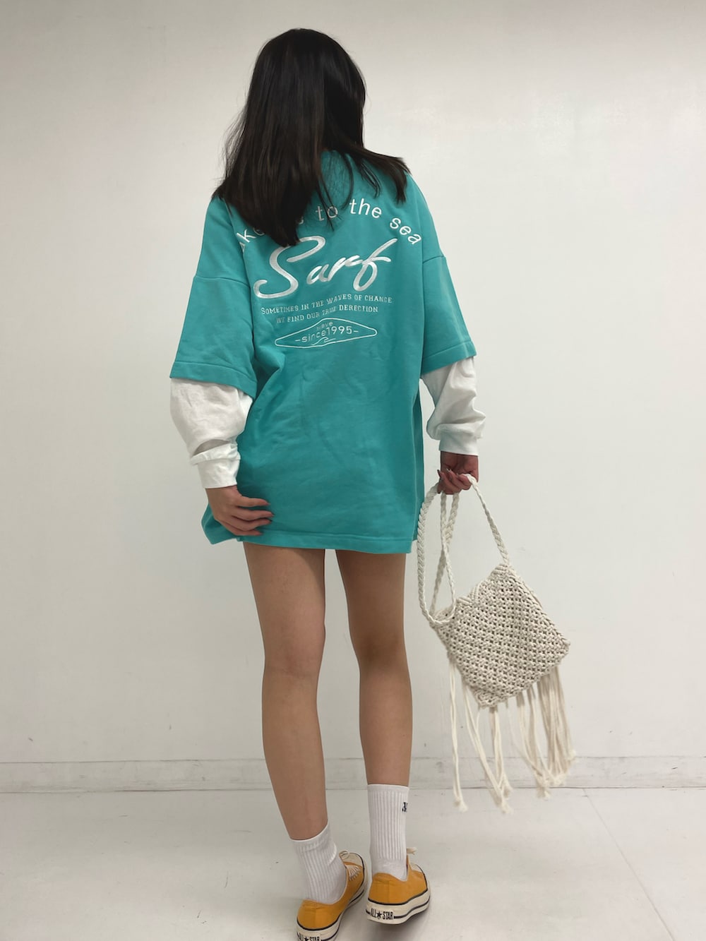 ブルー系のTシャツ/カットソー、ブルー系のデニムスカート、ホワイト系のショルダーバッグを着用したレディースの春コーディネートの2枚目の写真
