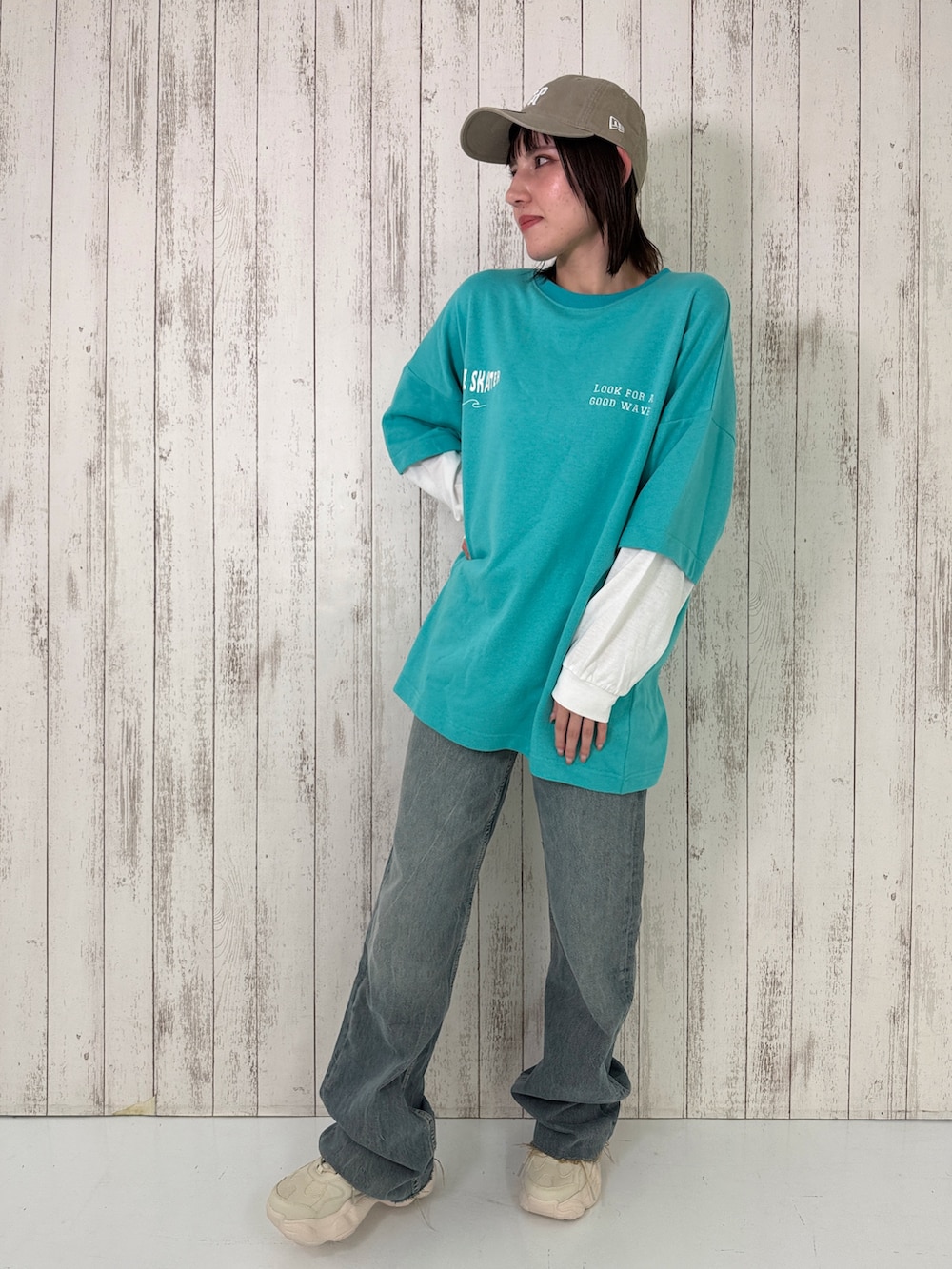 ブルー系のTシャツ/カットソー、ホワイト系のスニーカー、ベージュ系のキャップを着用したレディースの春コーディネートの5枚目の写真