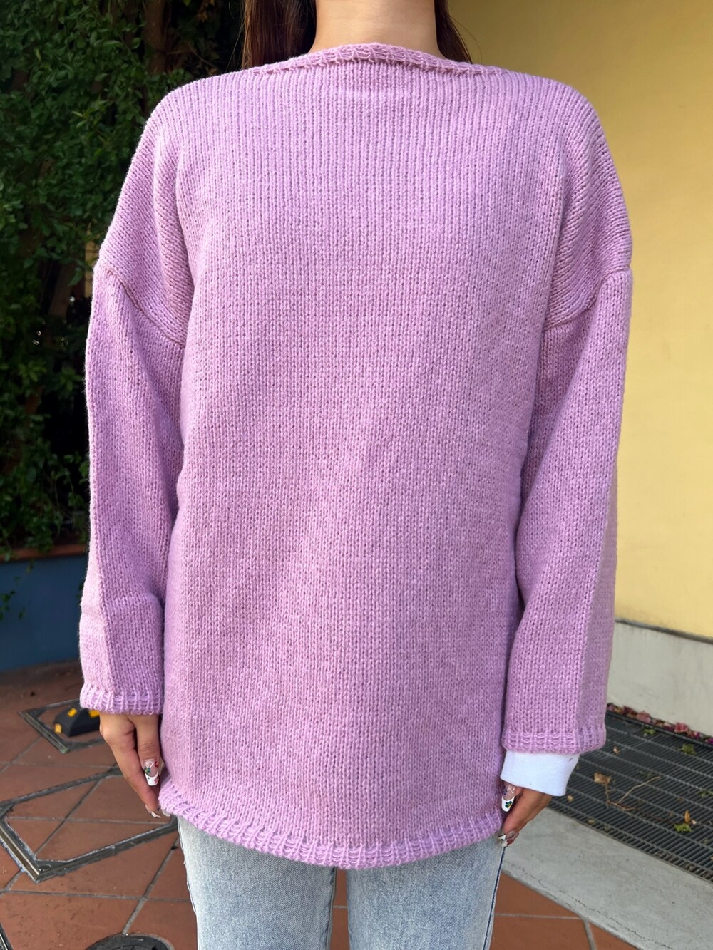 グリーン系のショルダーバッグ、パープル系のニット/セーター、ベージュ系のスニーカーを着用したレディースの冬コーディネートの3枚目の写真