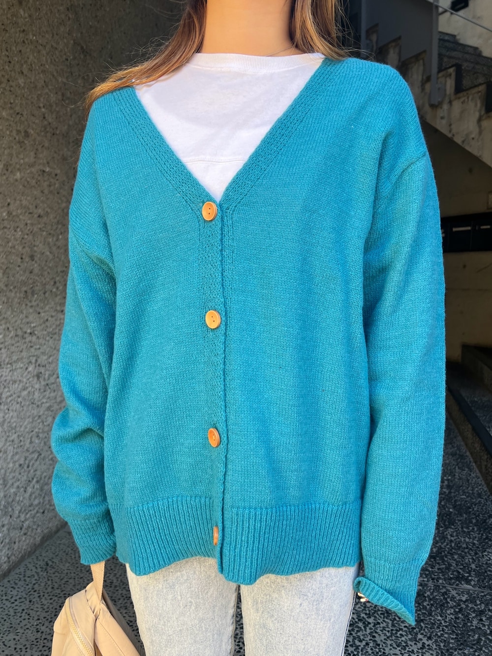 ブルー系のカーディガン/ボレロ、ベージュ系のバックパック/リュック、ベージュ系のスニーカーを着用したレディースの冬コーディネートの4枚目の写真