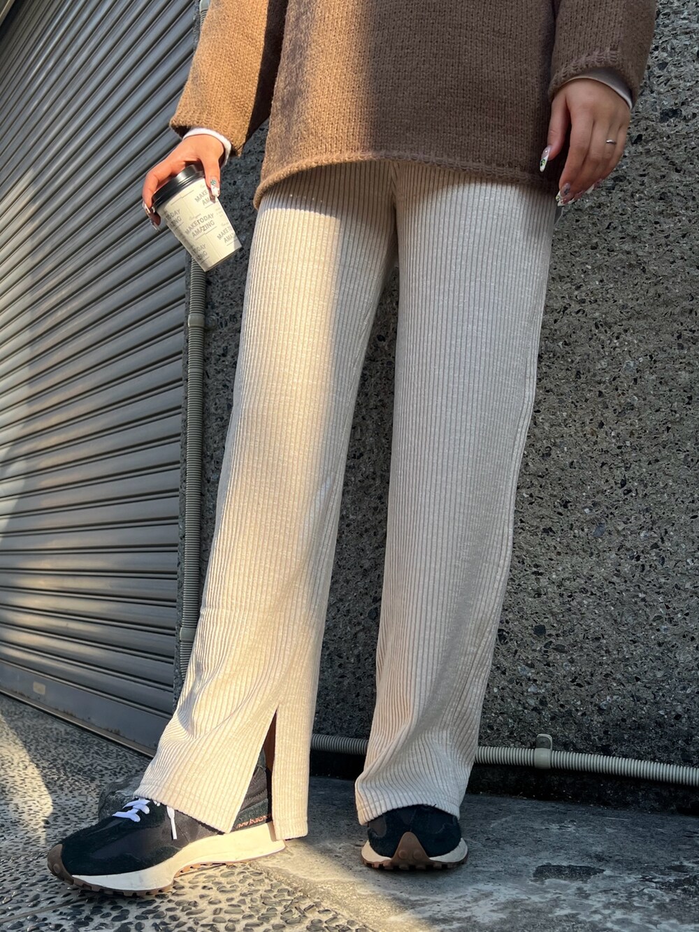 ブラウン系のニット/セーター、ベージュ系のその他パンツ、ブラック系のスニーカーを着用したレディースの冬コーディネートの4枚目の写真