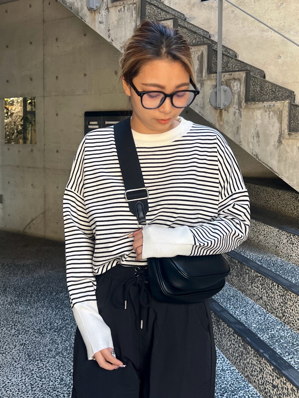 ブラック系のニット/セーター、ブラック系のショルダーバッグ、ブラック系のカーゴパンツを着用したレディースの春コーディネートの2枚目の写真