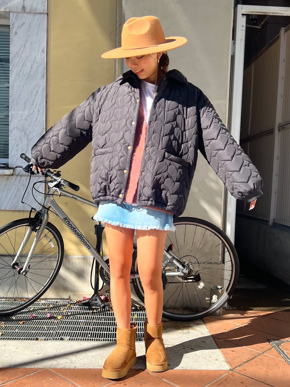 オレンジ系のカーディガン/ボレロ、ブラック系のブルゾン、イエロー系のブーツを着用したレディースの冬コーディネートの2枚目の写真