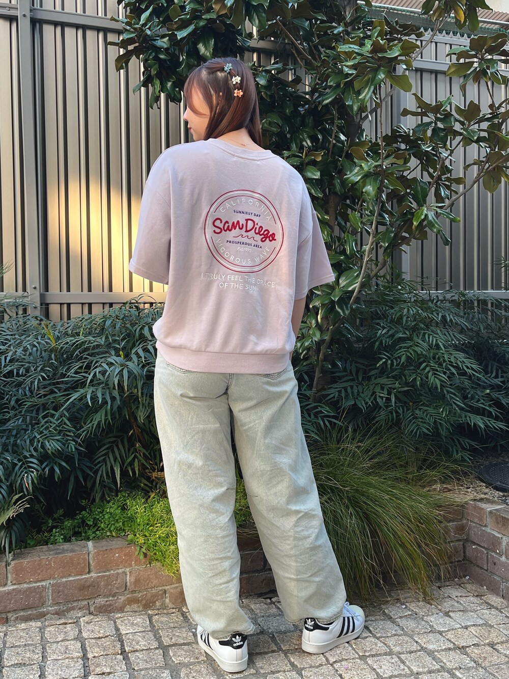 ピンク系のTシャツ/カットソー、ブルー系のデニムパンツ、オレンジ系のバレッタ/ヘアクリップを着用したレディースの春コーディネートの2枚目の写真