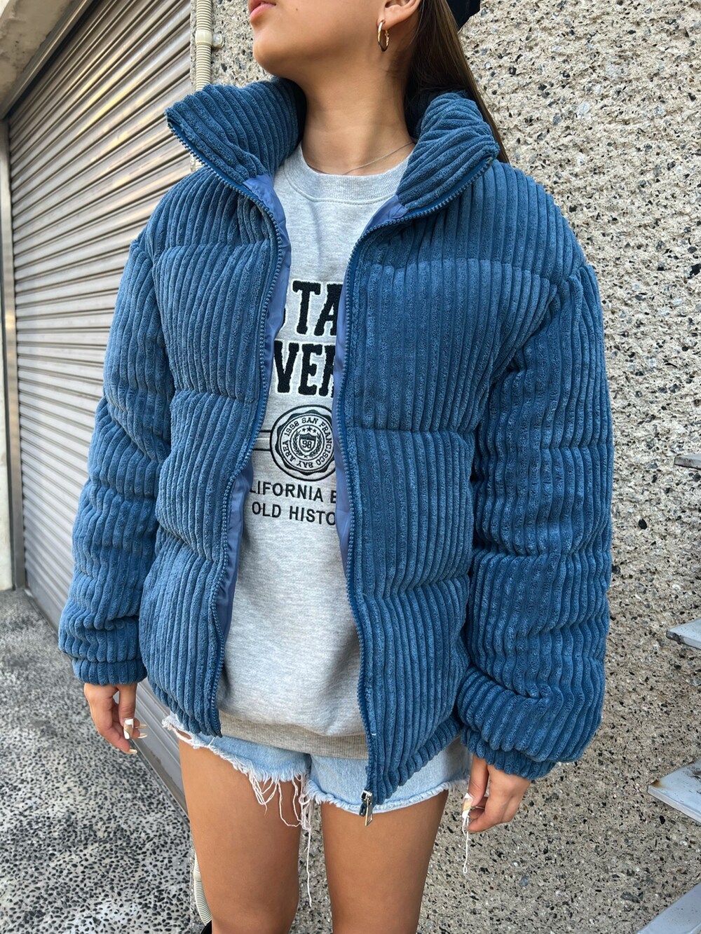 ブルー系のダウンジャケット/コート、グレー系のスウェット、ブラック系のショルダーバッグを着用したレディースの冬コーディネートの3枚目の写真